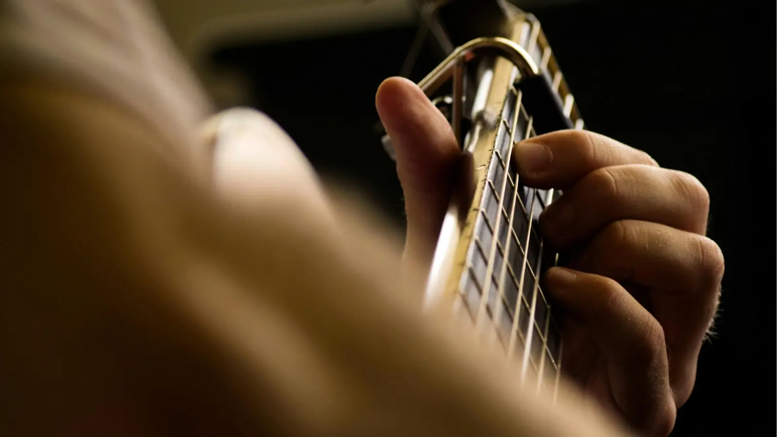 Hands playing a guitar neck